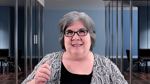 Woman speaking at AIIT conference in a modern office setting.