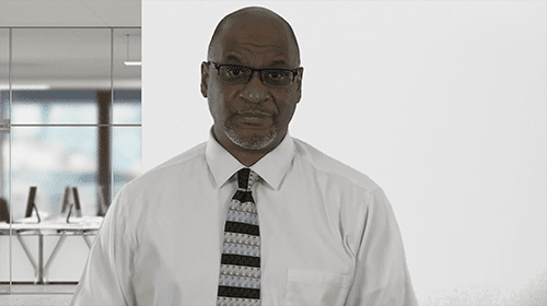 Professional man in office with glasses and tie, modern workspace background.