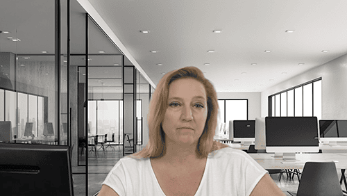 Modern office with large windows and computer workstations.